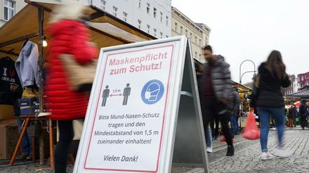 Ein Schild zu Maskenpflicht und Abstandsgebot auf dem Wochenmarkt auf dem Hermannplatz.