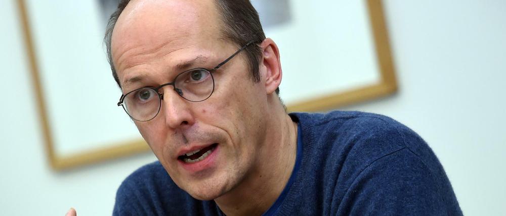 Mark Rackles gestikuliert, während er in ein Mikrofon spricht.