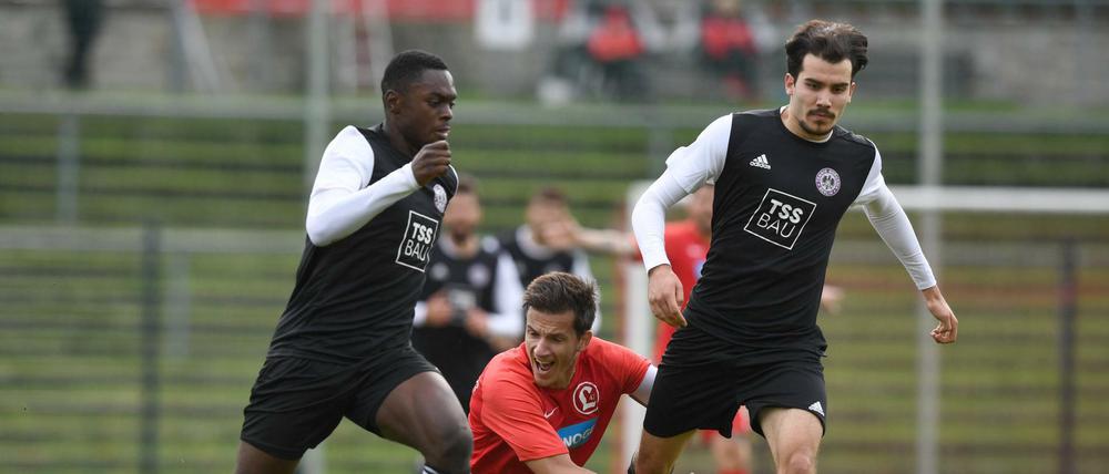 Am Spielen gehindert. Die Regionalliga-Fußballer von Tennis Borussia (dunkle Trikots) und Lichtenberg 47 werden wohl noch länger warten müssen, bis sie wieder auf den Platz dürfen.