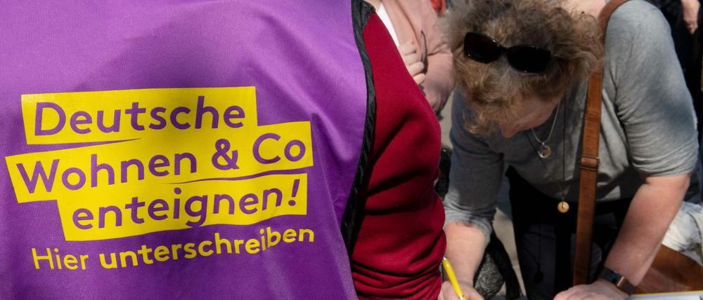 Beim bundesweiten Protesttag gegen steigende Mieten vom Bündnis gegen Verdrängung und #Mietenwahnsinn auf dem Alexanderplatz unterschreibt eine Frau eine Liste für die Enteignungsinitiative.