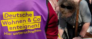 Beim bundesweiten Protesttag gegen steigende Mieten vom Bündnis gegen Verdrängung und #Mietenwahnsinn auf dem Alexanderplatz unterschreibt eine Frau eine Liste für die Enteignungsinitiative.