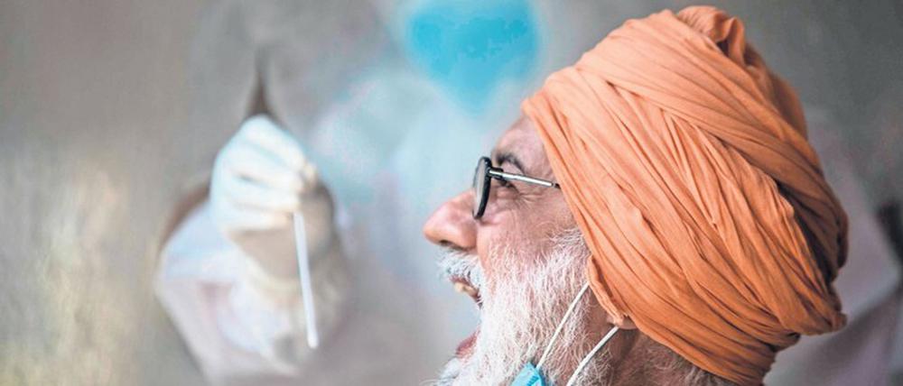 Ein Mann lässt sich in Delhi auf das Coronavirus testen.