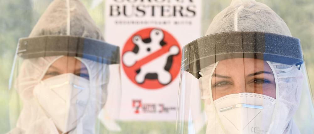 Mitarbeiter vom Gesundheitsamt in Mitte stehen in Schutzkleidung auf dem zentralen Festplatz in der ambulanten Corona-Test-Einrichtung.