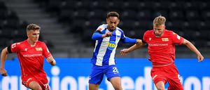 Selber Ort, selbe traurige Kulisse. Hertha (Mitte Matheus Cunha) und Union (rechts Marvin Friedrich, links Grischa Prömel) treffen im leeren Olympiastadion aufeinander. 