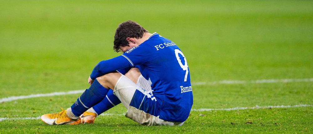 Schalkes Benito Raman sitzt nach dem Abpfiff auf dem Rasen. 