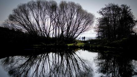 Warmer November: Spaziergänger am See „Dunsapie Loch“ bei Edinburgh 