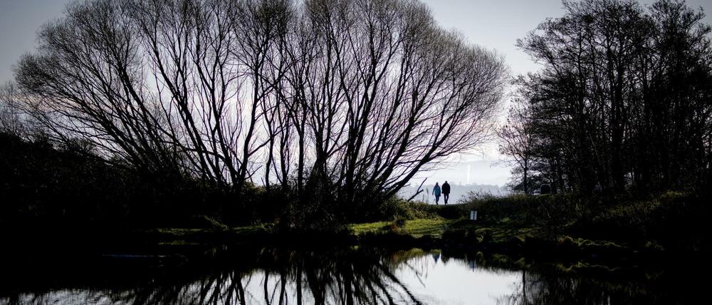 Warmer November: Spaziergänger am See „Dunsapie Loch“ bei Edinburgh 