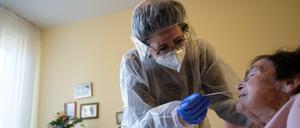 Eine Altenpflegerin führt einen Antigen-Corona-Schnelltest durch.