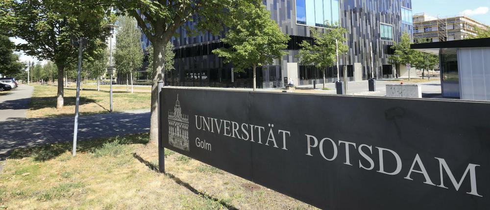 Das Schild der Universität Potsdam im Vordergrund und die Gebäude im Hintergrund.