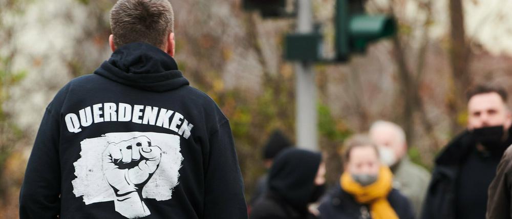22.11.2020, Berlin: ·Querdenken Frieden Freiheit Widerstand· steht auf der Rückseite des Pullovers eines Demonstranten bei einer Demonstration, die als «Schweigemarsch» bezeichnet wird und sich gegen die Corona-Politik der Bundesregierung richtet. Foto: Annette Riedl/dpa +++ dpa-Bildfunk +++