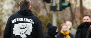 22.11.2020, Berlin: ·Querdenken Frieden Freiheit Widerstand· steht auf der Rückseite des Pullovers eines Demonstranten bei einer Demonstration, die als «Schweigemarsch» bezeichnet wird und sich gegen die Corona-Politik der Bundesregierung richtet. Foto: Annette Riedl/dpa +++ dpa-Bildfunk +++