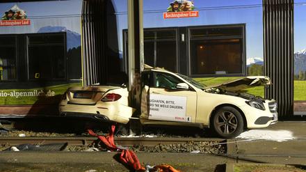 Das Taxi steht nach der Kollision mit einer Straßenbahn eingeklemmt zwischen einem Mast und der Straßenbahn am Unfallort.