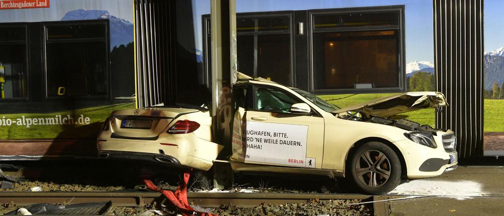 Das Taxi steht nach der Kollision mit einer Straßenbahn eingeklemmt zwischen einem Mast und der Straßenbahn am Unfallort.