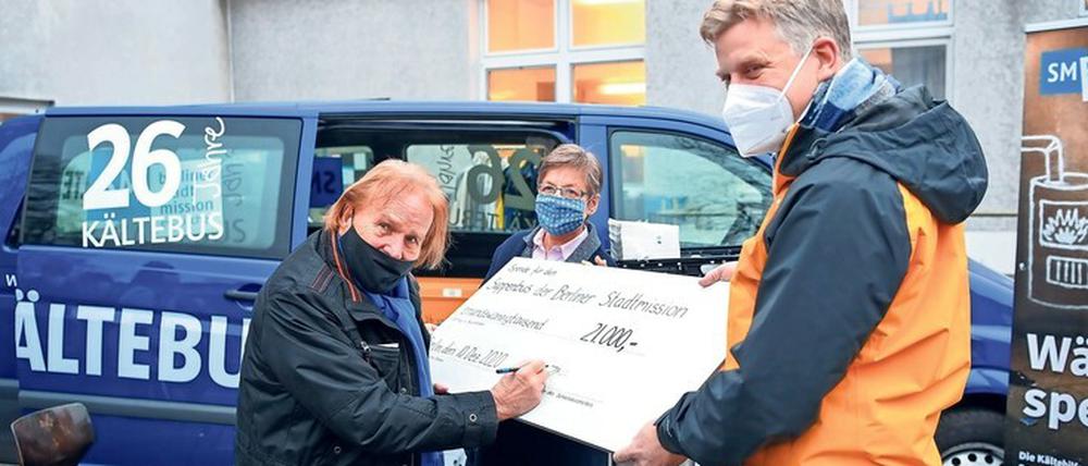 Sänger Frank Zander überreicht den Spendencheck an Barbara Eschen (Diakonie) und Christian Ceconi (Stadtmission).