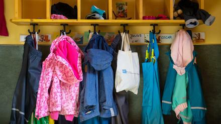 Jacken und Taschen hängen im Eingangsbereich in einem Kindergarten.