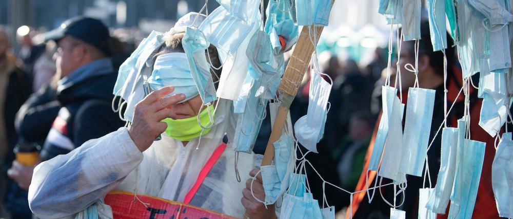 Masken - nicht zum Aufsetzen, nur als Demo-Objekt. Teilnehmerin einer "Querdenker"-Demonstration gegen die Maßnahmen der Politik im Kampf gegen die Corona-Pandemie.