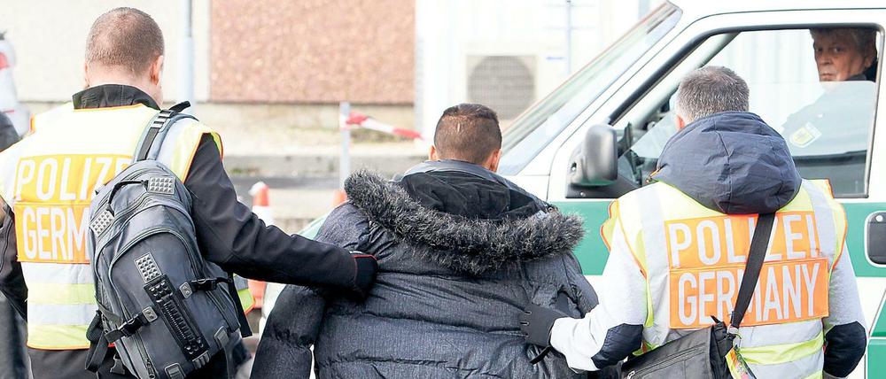 Polizisten begleiten einen straffällig gewordenen Asylbewerber zum Flughafen Leipzig (Archiv).