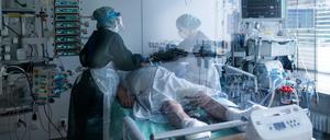 In einem Krankenhaus betreuten Mitarbeiterinnen der Pflege in Schutzausrüstung einen Corona-Patienten.