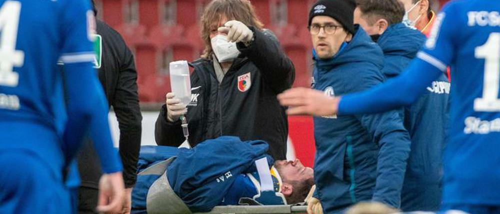 Schlimmes Bild. Mark Uth wird mit einer Trage vom Platz gebracht.