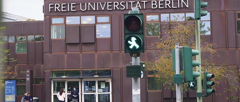 Grüne Fußgängerampel vor einem Hauptgebäude der Freien Universität Berlin.