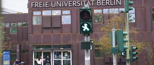 Grüne Fußgängerampel vor einem Hauptgebäude der Freien Universität Berlin.