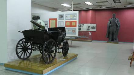 Im Frunse-Museum: Im Vordergrund ein Leiterwagen mit Maschinengewehr aus dem Russischen Bürgerkrieg, hinten eine eine Bronzestatue von Michail Frunse.