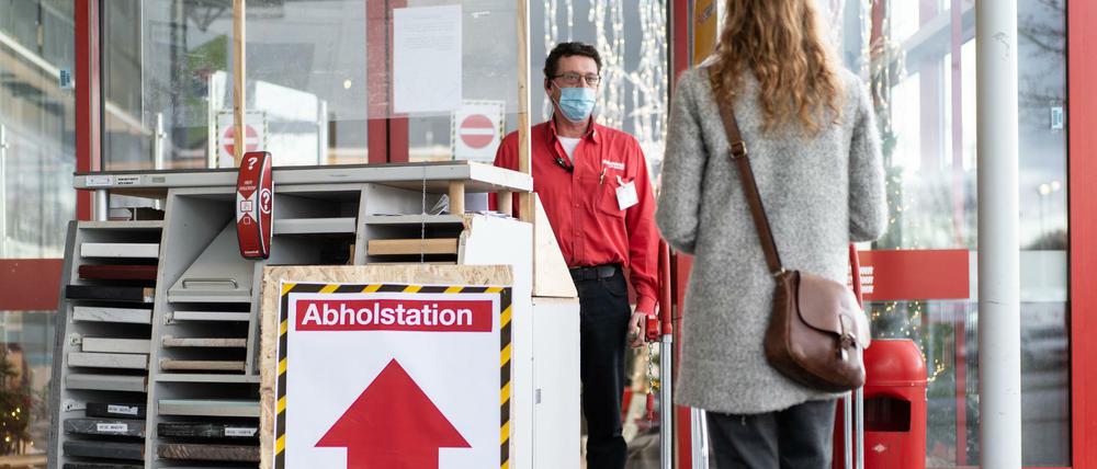 Eine Kundin nimmt an einer Abholstation am Toom-Baumarkt ihre vorab über das Internet bestellten Waren in Empfang.