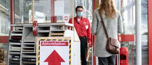 Eine Kundin nimmt an einer Abholstation am Toom-Baumarkt ihre vorab über das Internet bestellten Waren in Empfang.