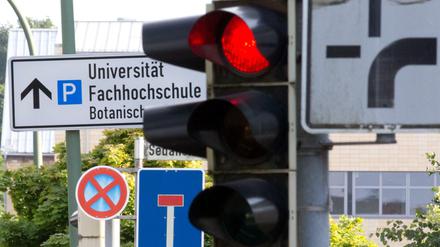 Eine rote Ampel und Verkehrsschilder für "Sackgasse" und "absolutes Halteverbot" sind am 28.07.2015 in Osnabrück (Niedersachsen) vor einem Hinweis auf Universität und Fachochschule zu sehen.