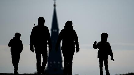 Fußgänger gehen in der Dresdner Neustadt auf einem Hügel mit Blick auf die Garnisonkirche St. Martin spazieren.
