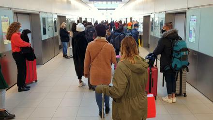 Passagiere stehen im Flughafen Gatwick in einer Schlange für einen Shuttlezug.