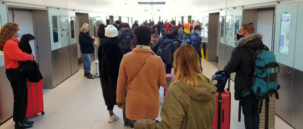 Passagiere stehen im Flughafen Gatwick in einer Schlange für einen Shuttlezug.