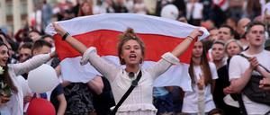 Eine junge Frau demonstriert im August mit Fahne gegen den Diktator Alexander Lukaschenko. 