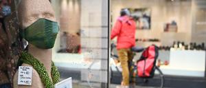 Kurz vor Weihnachten 2020: Eine Radfahrerin betrachtet die Auslage eines geschlossenen Geschäftes am Kurfürstendamm. Nur wenige Passaten waren auf der sonst so beliebten Shopping-Meile unterwegs.