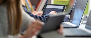 Schüler:innen arbeiten in einer Schulklasse an ihren Laptops.
