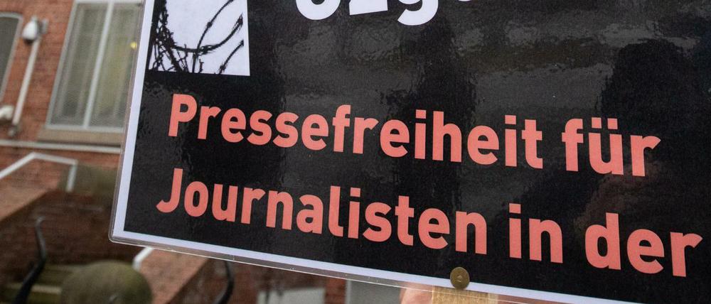  In Hamburg lebende Journalistinnen und Journalisten aus der Türkei stehen mit einem schwarzen Kranz vor dem Türkischen Konsulat. Die symbolische Aktion sollte ein Zeichen für Pressefreiheit und Solidarität mit inhaftierten Kollegen setzen. 