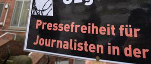 In Hamburg lebende Journalistinnen und Journalisten aus der Türkei stehen mit einem schwarzen Kranz vor dem Türkischen Konsulat. Die symbolische Aktion sollte ein Zeichen für Pressefreiheit und Solidarität mit inhaftierten Kollegen setzen.