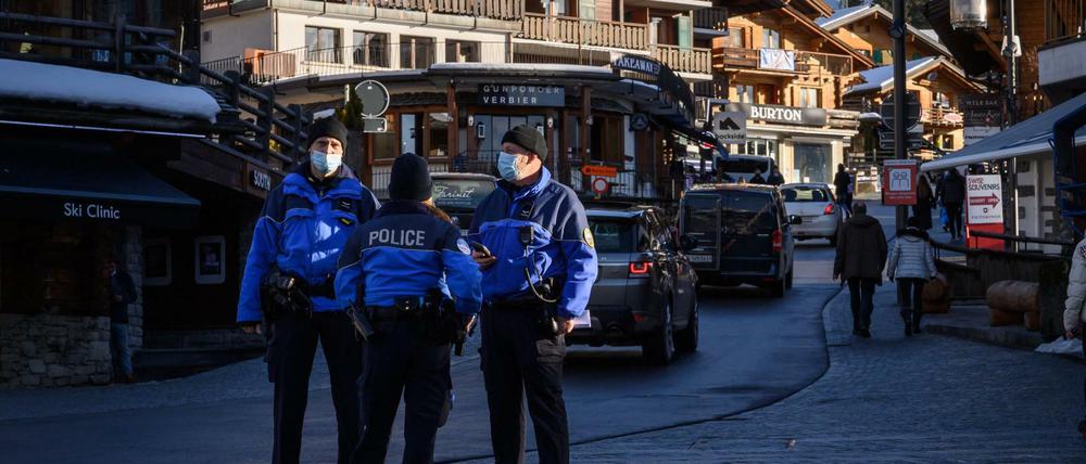 Polizisten stehen in Verbier, Schweiz und kontrollieren die Quarantäne. Viele Briten sind über Nacht abgehauen.