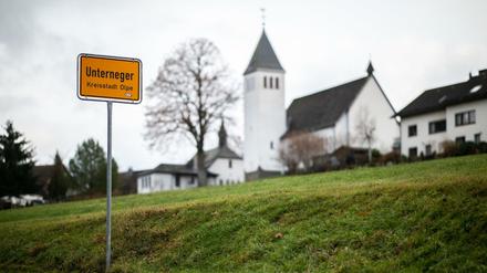 Das Ortsschild des Ortsteils Unterneger steht vor der St. Barbara- und St. Luzia-Kirche. 