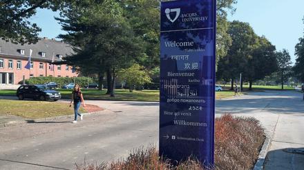 Ein Aufsteller auf dem Campus der Jacobs University, auf dem Besucher:innen in vielen Sprachen willkommen geheißen werden.