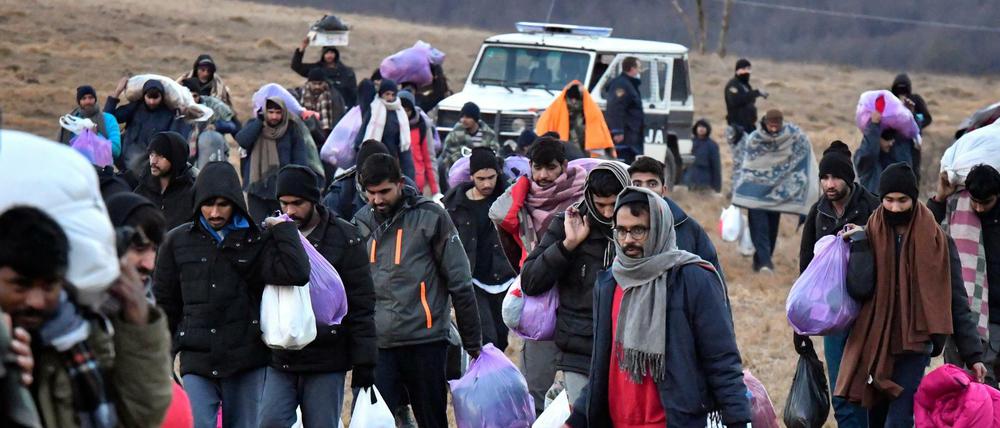 Migranten gehen mit ihren Habseligkeiten zurück zum Lager Lipa in Bosnien-Herzegowina.