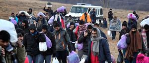 Migranten gehen mit ihren Habseligkeiten zurück zum Lager Lipa in Bosnien-Herzegowina.
