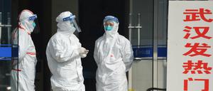 Medizinisches Personal in Schutzanzügen wartet im Januar 2020 am Eingang einer Klinik für Patienten aus Wuhan. 