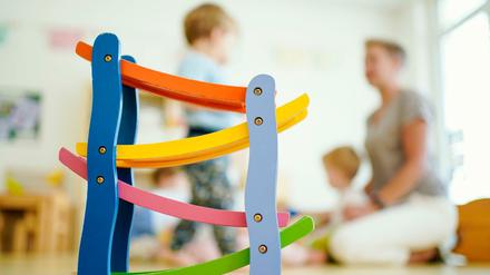 Eine Erzieherin spielt in einer Kindertagesstätte mit Kindern.