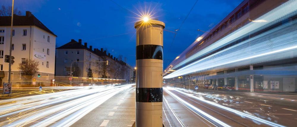 Eine Blitzsäule mit kombinierter Überwachung von Rotlicht und Geschwindigkeit steht an einer Ampelkreuzung. 