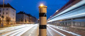 Eine Blitzsäule mit kombinierter Überwachung von Rotlicht und Geschwindigkeit steht an einer Ampelkreuzung. 