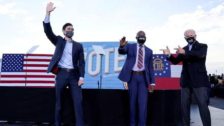 Joe Biden (r) zeigt auf die demokratischen Kandidaten für den Senat: Jon Ossoff (l) und Raphael Warnock (m).