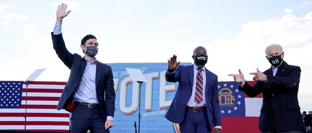 Joe Biden (r) zeigt auf die demokratischen Kandidaten für den Senat: Jon Ossoff (l) und Raphael Warnock (m).