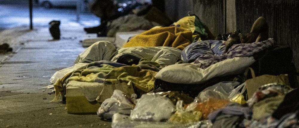 Obdachlose Menschen liegen unter einer Brücke am Bahnhof Zoo.