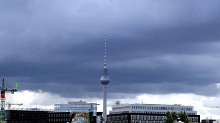 Dunkle Regenwolken hängen über dem Fernsehturm am Alexanderplatz in Berlin.